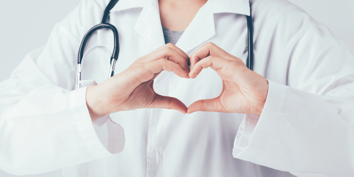 Healthcare worker with hands in the shape of a heart